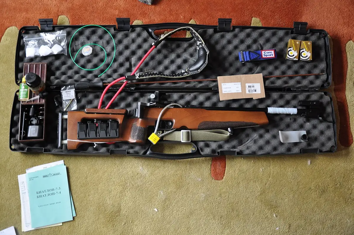 Rifle stored in an open foam-lined hard case with accessories