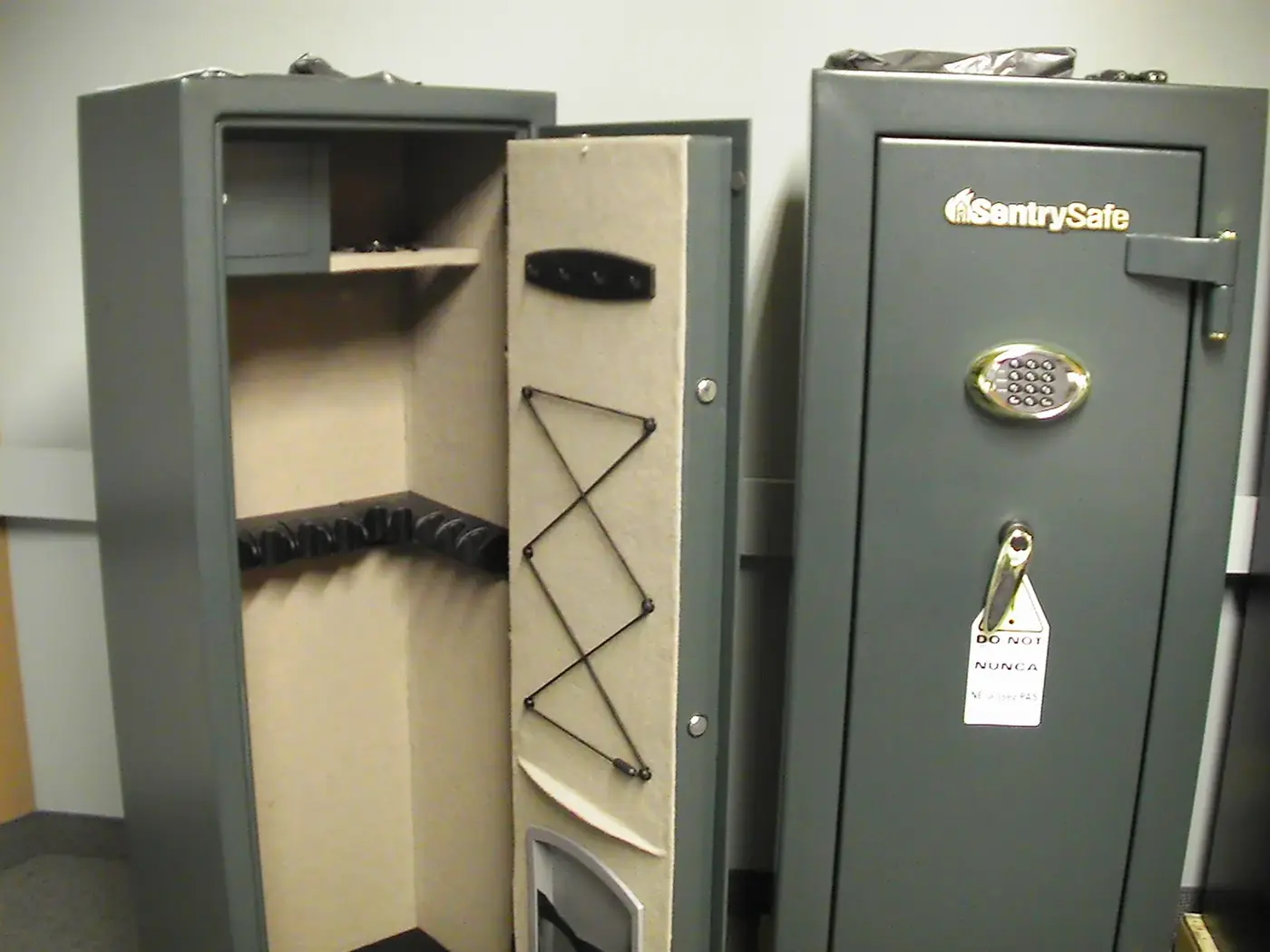 Two upright gun safes, one open showing the rifle rack and door storage