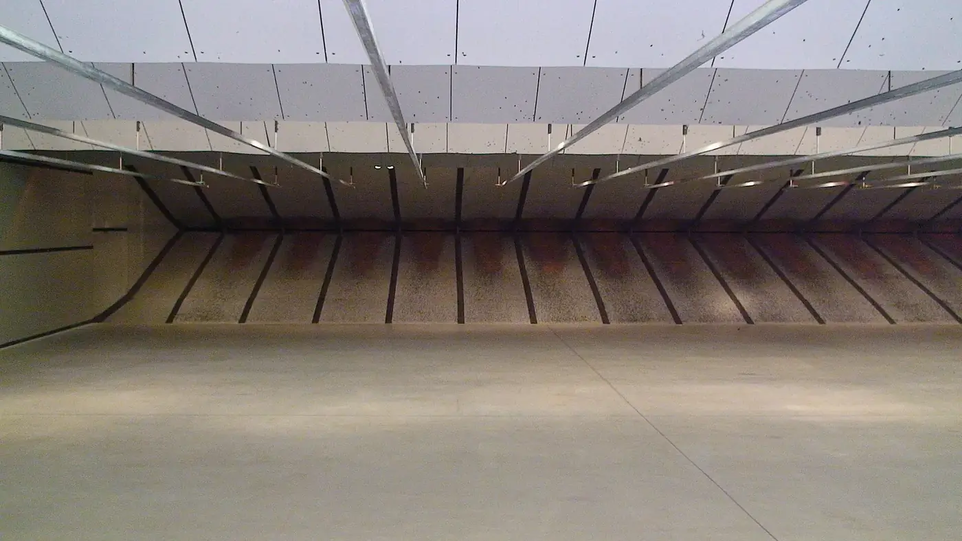 Empty indoor firing range with overhead baffles and target lanes